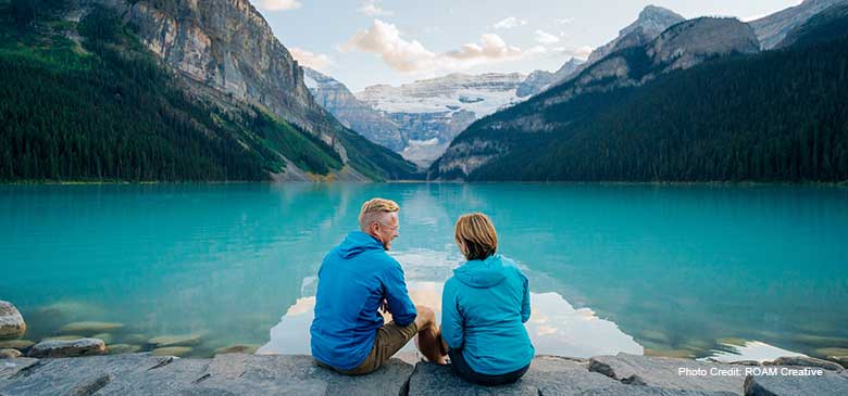 couple sitting by lake louise